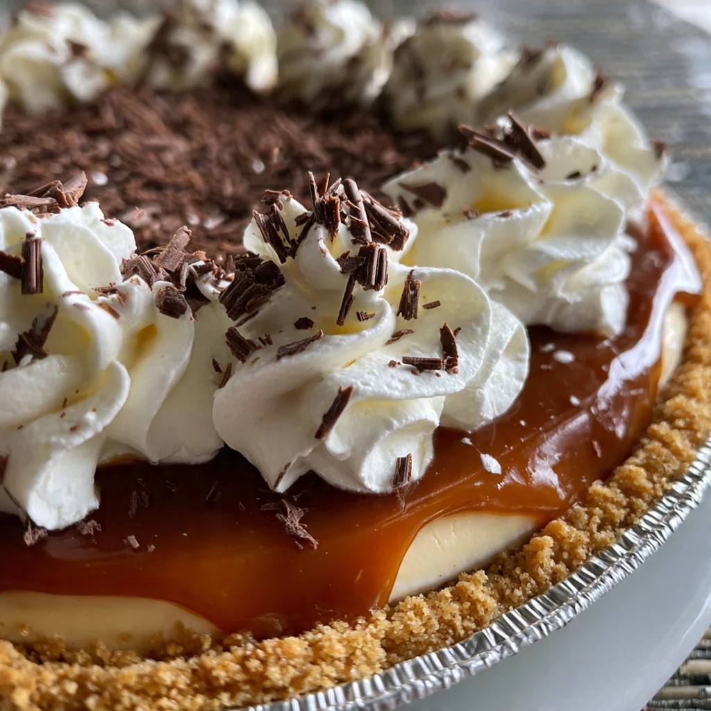 A finished caramel pie on a rustic table with a sprinkle of flaky sea salt on top