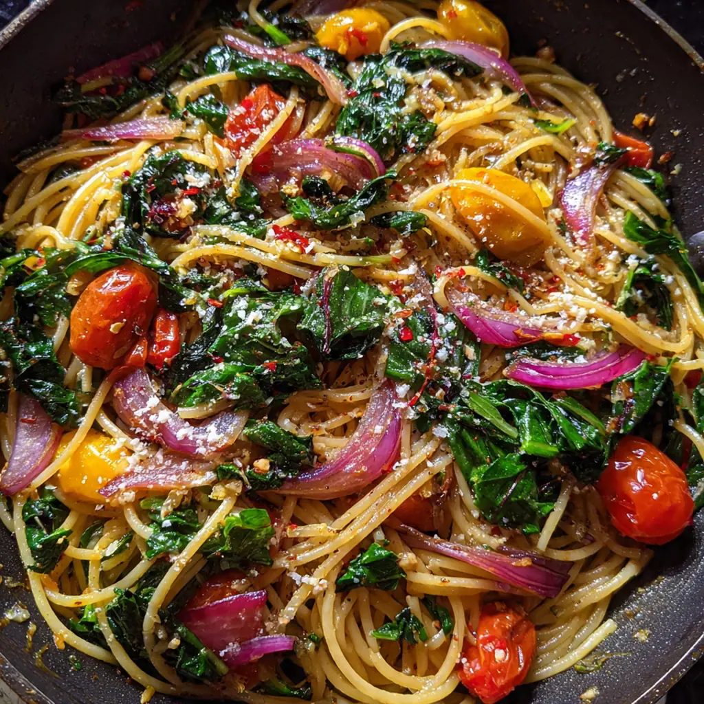 Beautiful plated serving of one pan spaghetti chard next to a slice of crusty garlic bread and a glass of red wine
