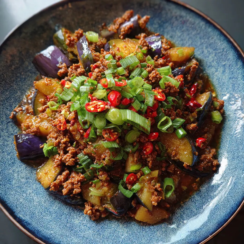 A bowl of steamed jasmine rice topped with a generous serving of the fiery eggplant and pork stir-fry